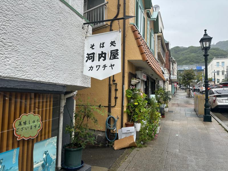 神戸北野トアロード沿いのそば処河内屋の吊り看板とガス灯のある歩道